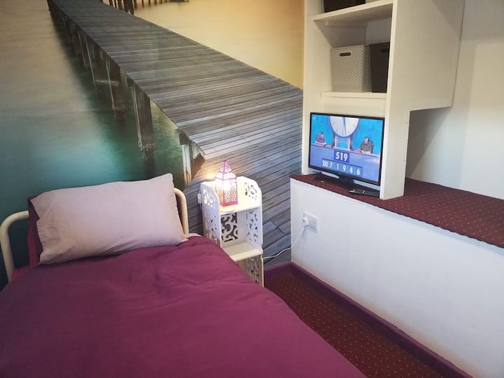 غرفة النوم 4، الطابق الثاني. سرير فردي، تلفزيون. لوحة جدارية. 