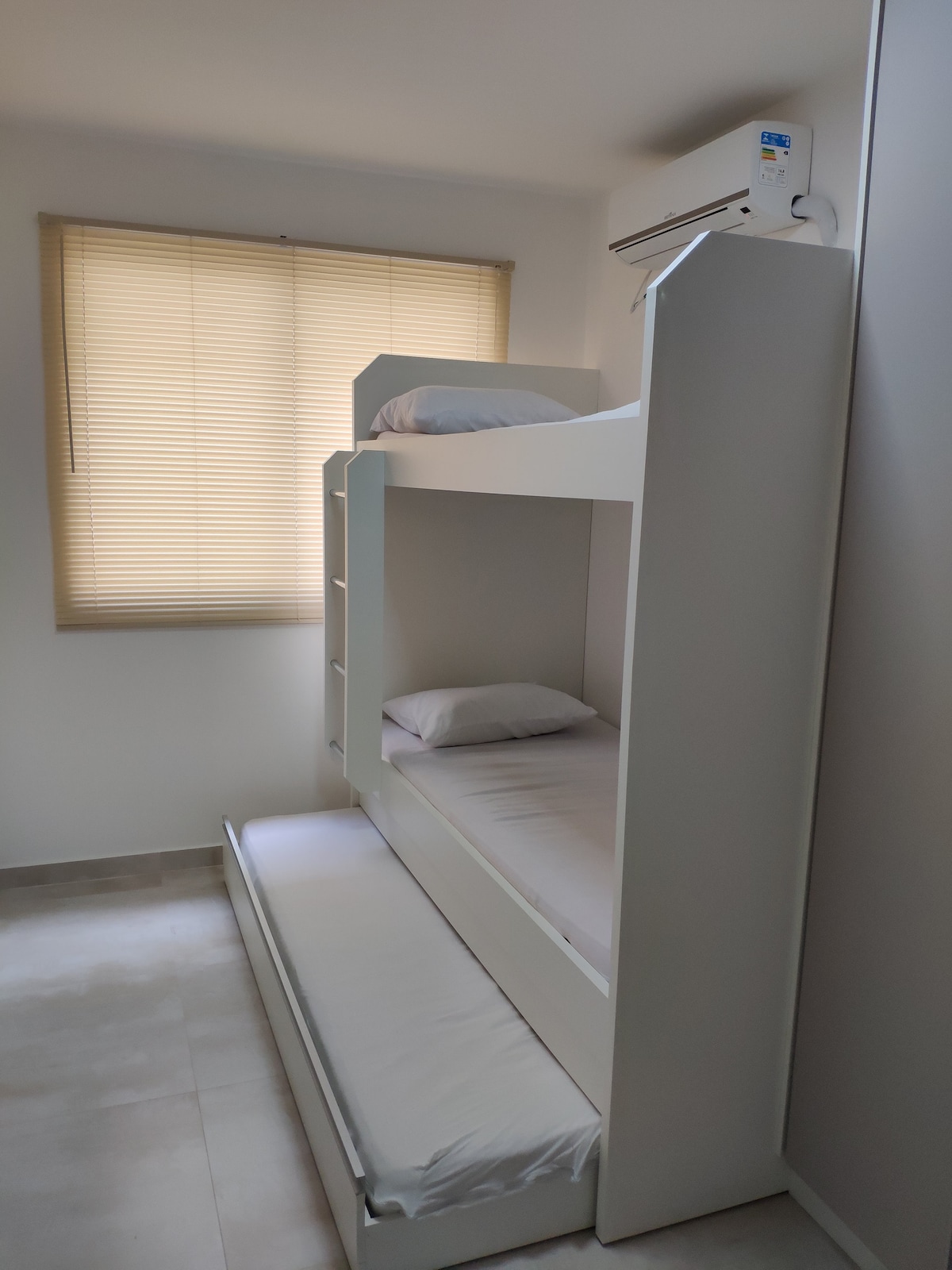 Habitación con treliche, aire acondicionado y armario.