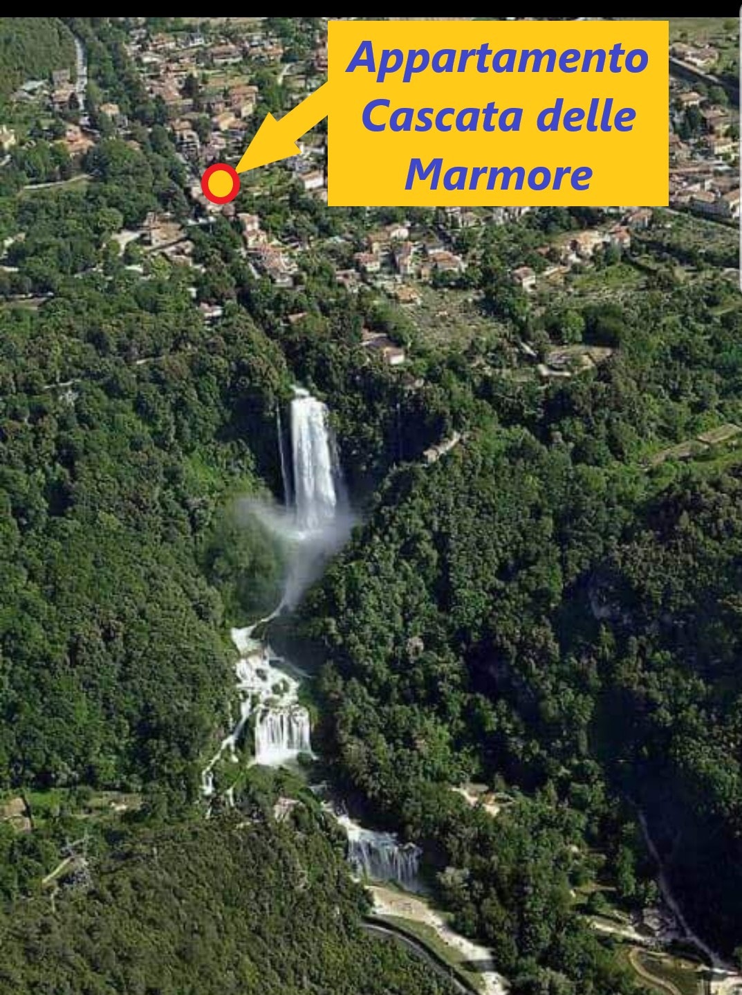 Aerial view showcases the lush green landscape surrounding the Cascata delle Marmore, with cascading waterfalls visible amid a blend of natural vegetation and residential structures. Proximity to the apartment is indicated with a marker, highlighting its location near this natural attraction.