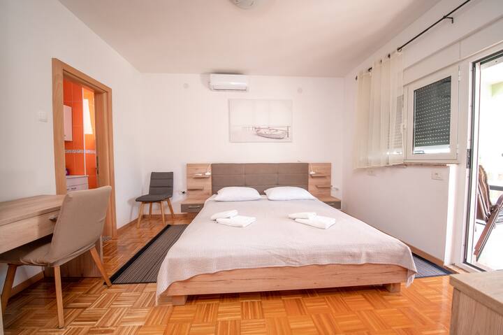 חדר שינה עם מיזוג אוויר, מיטת קינג סייז, טלוויזיה, מרפסת וחדר רחצה פרטי.