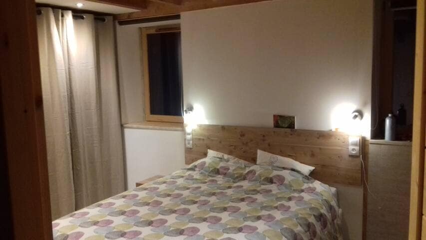 პირველი სართულის საძინებელი, კედელზე მიმაგრებული ტელევიზორი და ცალკე სააბაზანო.