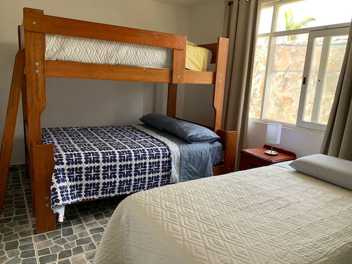 غرفة نوم بسرير بطابقين وسرير إضافي.
