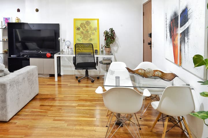 Mtazamo wa sebule na mapambo safi, ya kisasa na yasiyosamehewa, lakini yanahifadhi uzuri na haiba yake.

Kwa usuli, dawati la kazi lenye Wi-Fi ya kasi: 350Mbps, taa ya umeme na kiti cha ergonomic. Televisheni 55", Soundbar, net cable TV.