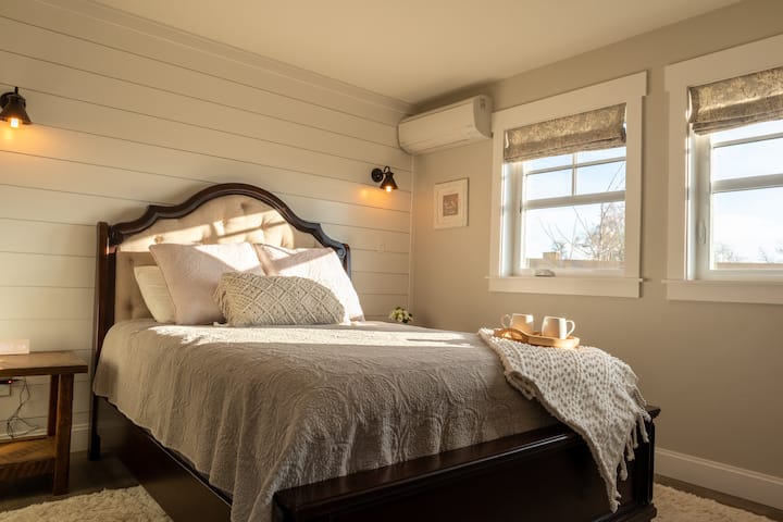 DORMITORIO PRINCIPAL: ropa de cama y almohadas lujosas y acogedoras en un colchón tamaño queen de calidad. Dos ventanas para permitir la luz natural, equipadas con cortinas romanas para la siesta durante el día. 