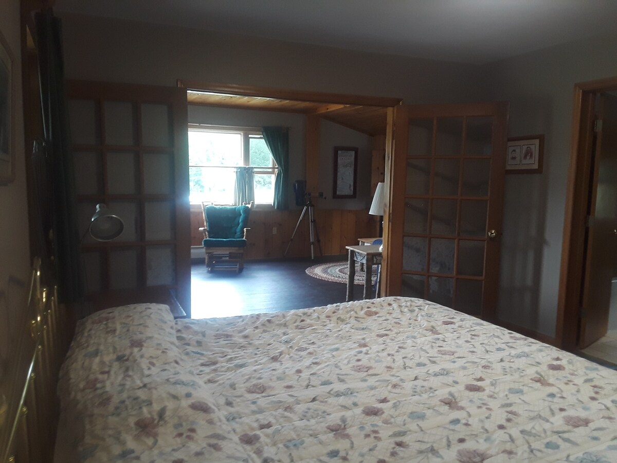 Დიდი საწოლი; საძინებელი მისაღებ ოთახში, რომელშიც დგას გასაშლელი დივანი და ბუხარი.