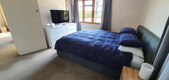 سرير كبير وغرفة كبيرة مزودة بالتلفاز.