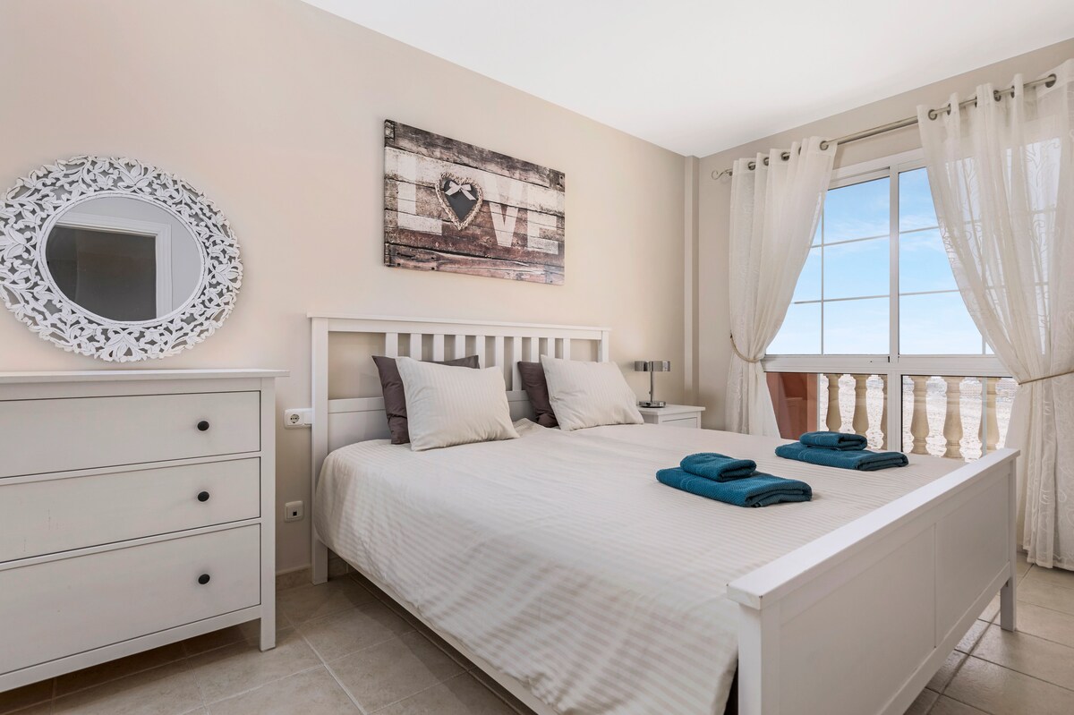 ห้องนอนพร้อมเตียงคู่ขนาดใหญ่และวิวทะเลที่งดงาม 