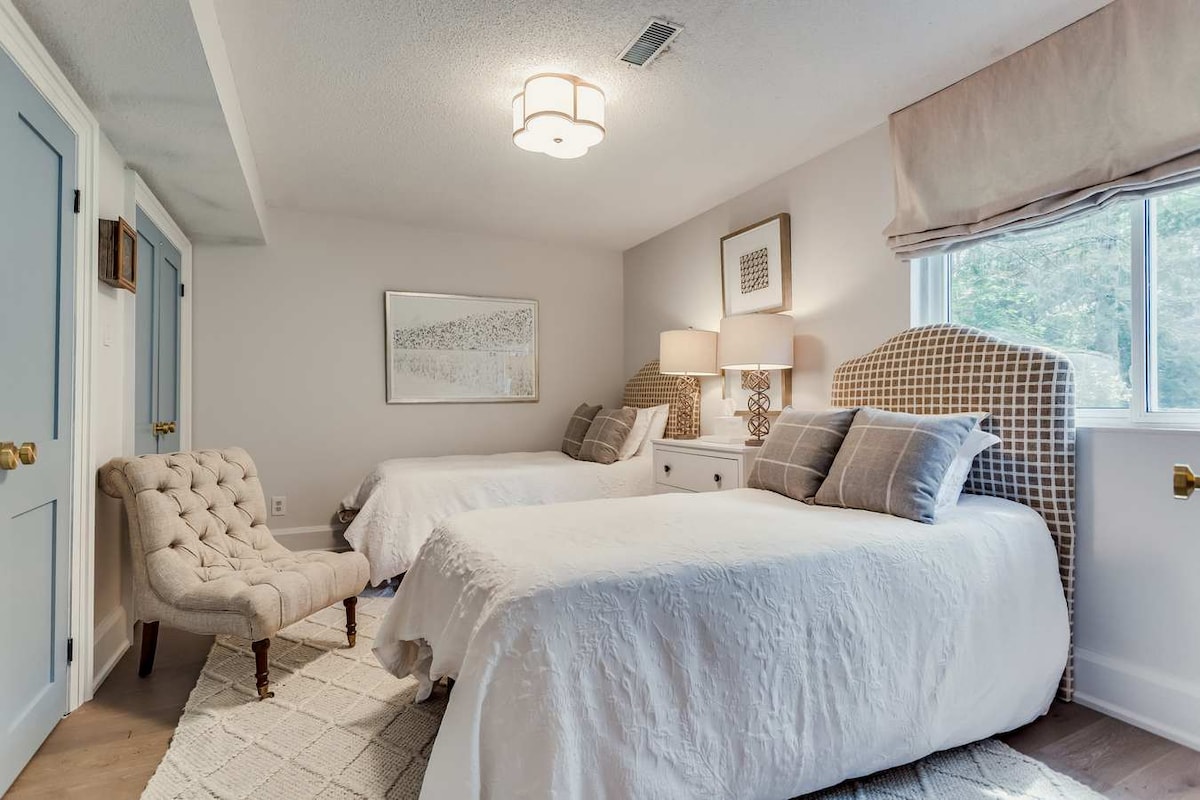 main floor bedroom room with 2 twin beds bathroom off hall