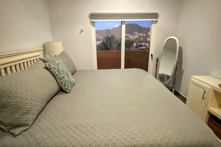 غرفة نوم رئيسية مع سرير مريح بحجم كبير وحشو رغوي وغطاء خفيف.  إطلالة جميلة على جبال الصحراء.