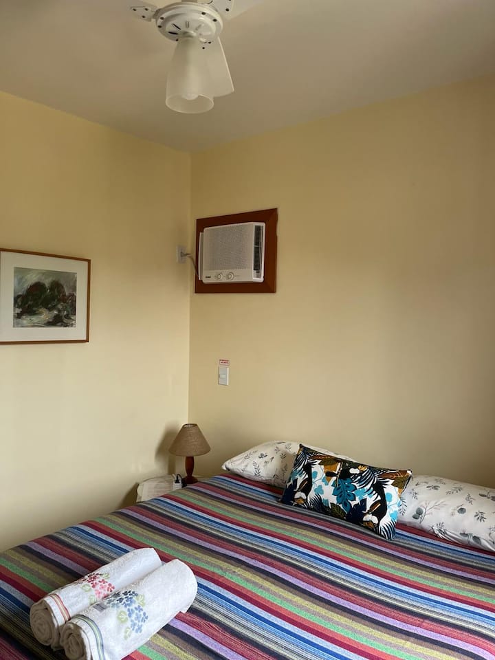 Dormitorio doble/detalle en suite con aire acondicionado y ventilador de techo.