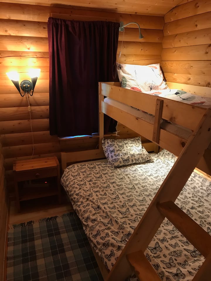 第二间卧室配有家庭双层床、阅读灯、床头柜和电源插座。