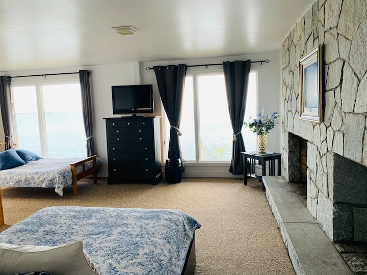 Dormitorio 4: el dormitorio del nivel inferior con dos camas completas, baño completo, chimenea, con vistas al mar desde ambas camas.