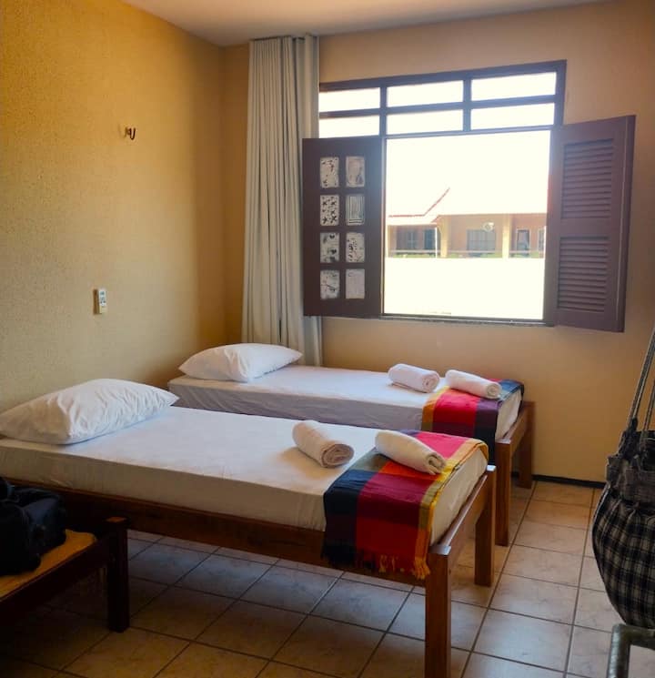 Mwonekano wa mlango wa chumba cha kulala cha pili ulio na malazi mawili ya mtu mmoja, kitanda cha bembea katika chumba cha kulala, kiyoyozi na kitanda cha usaidizi kwa ajili ya kufunga masanduku