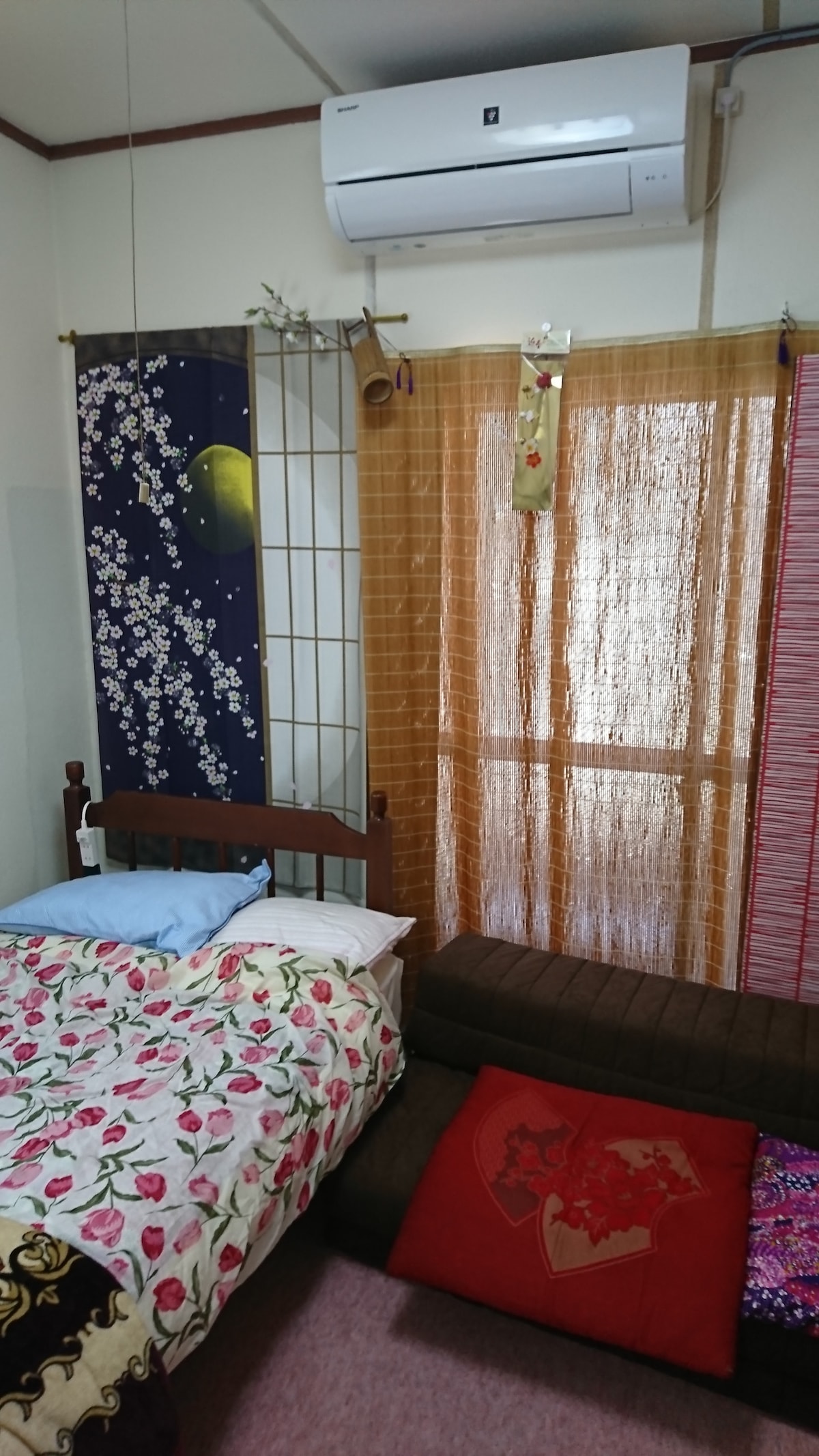 Posteľ v spálni na severnej strane izby 101 a jednoduchá pohovka (dvojitá posteľná bielizeň) na severnej strane izby 101.