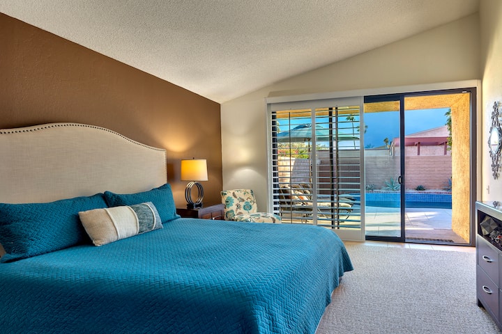 חדר שינה קליפורני מואר ושטוף שמש במרחק כמה צעדים מבריכה מחוממת וספא מוקפים בקירות פרטיות בגובה 1.8 מטר, תריסי עץ הזזה להחשכת החדר, חדר ארונות, טלוויזיה חכמה, חדר רחצה צמוד עם אמבטיה שקועה, מקלחת ושירותים.