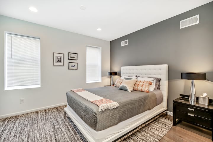 Chic and cozy bedroom featuring a plush tufted headboard, moody accent wall and sophisticated décor.