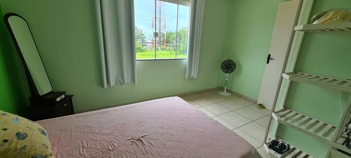 Zelena soba s bračnim krevetom, posteljinom i kadom, pogledom na more, ventilatorom i mrežom za komarce.