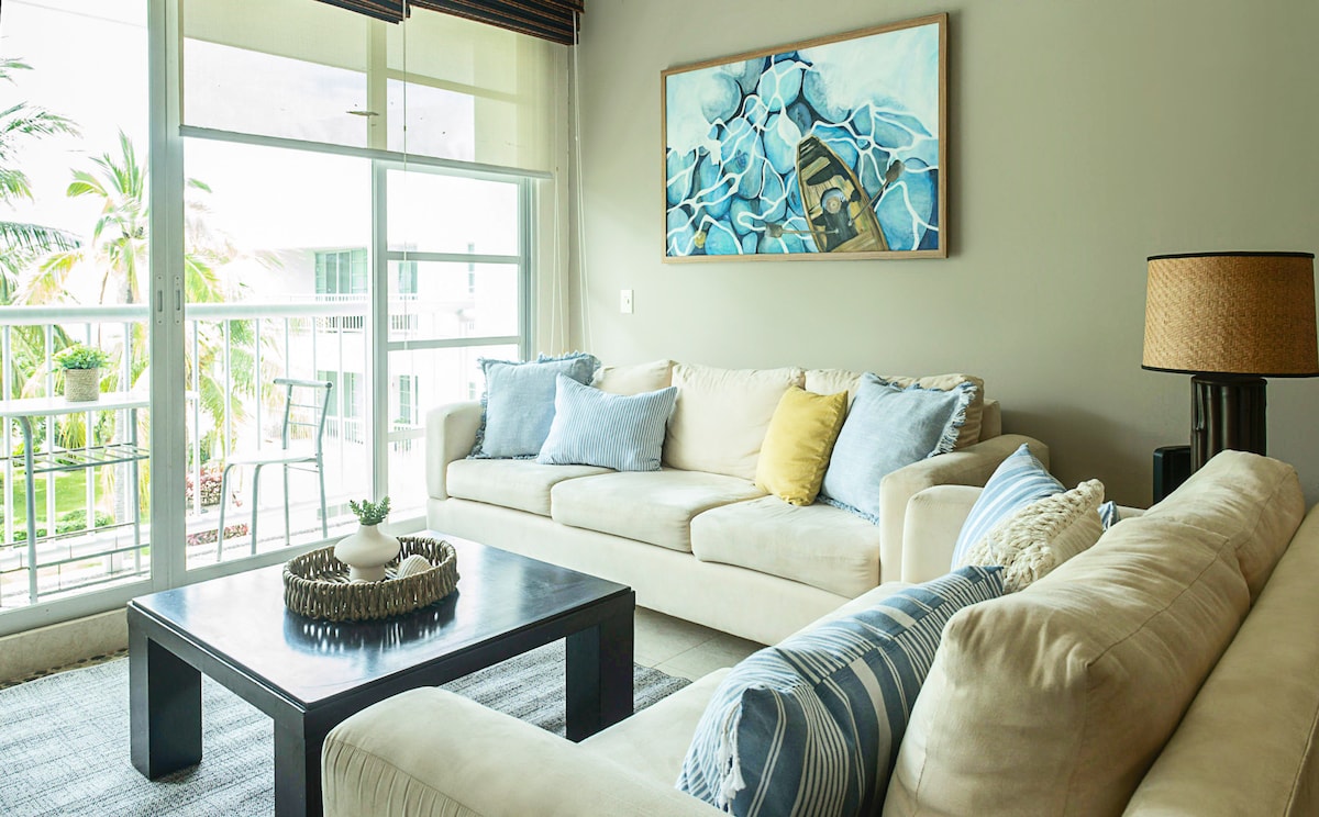 ✨ ✨ סלון: מרווח ומלא באור טבעי, עם ספות בצבע בז' וכריות בגוונים רכים שמזמינים אתכם להירגע מול החלון המשקיף על הגנים, האגמים והבריכות.