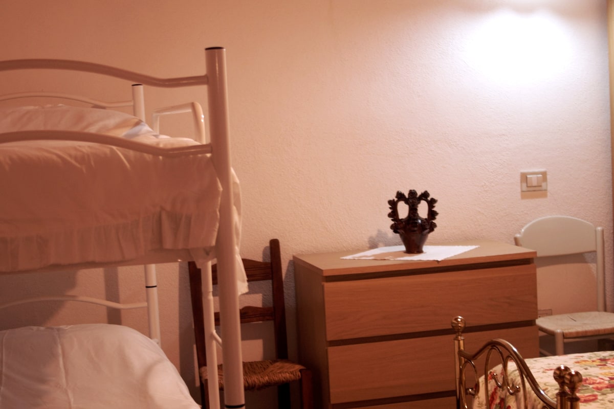 غرفة نوم بسرير بحجم كبير وسريرين بطابقين