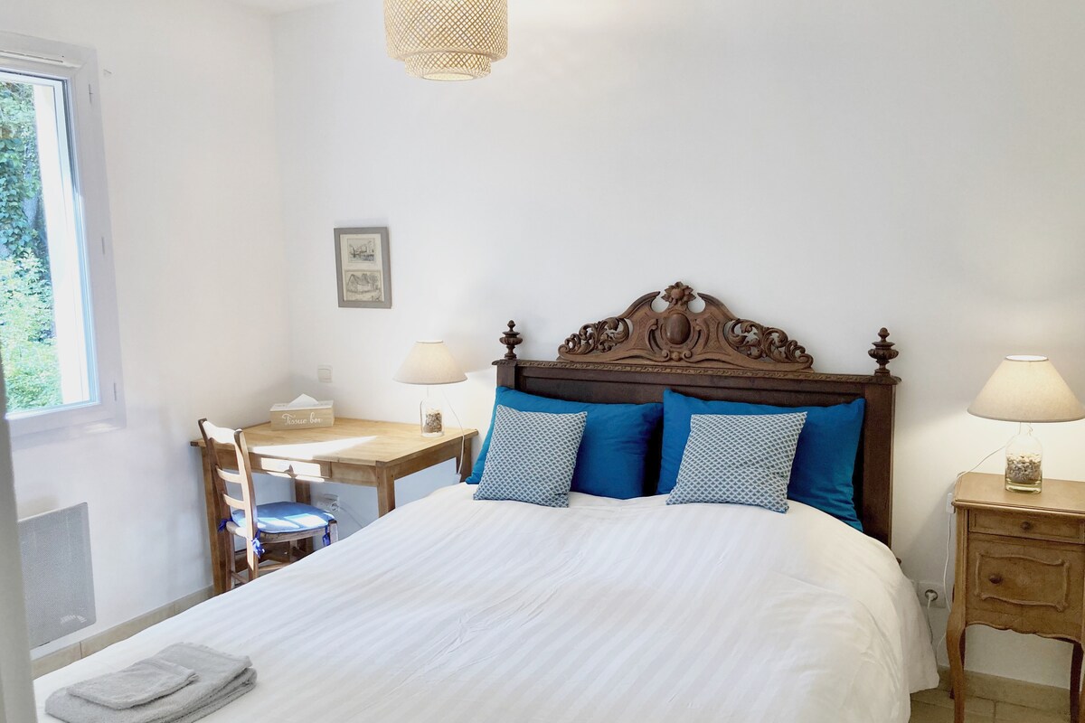 غرفة النوم في الطابق الأرضي: إطلالة على الجزء الخلفي من المنزل والنباتات. سرير بعرض 160 سم، بدون لوح قدم، مكتب صغير يمكن استخدامه أيضًا كطاولة لتغيير الملابس وخزانة ملابس وطاولة بجانب السرير