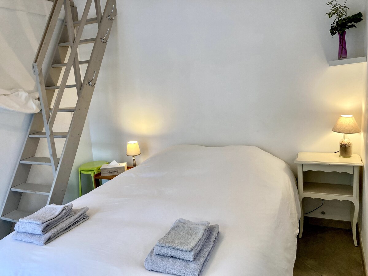 يوفر الدرج الخشبي إمكانية الوصول إلى منطقة نوم في الميزانين.