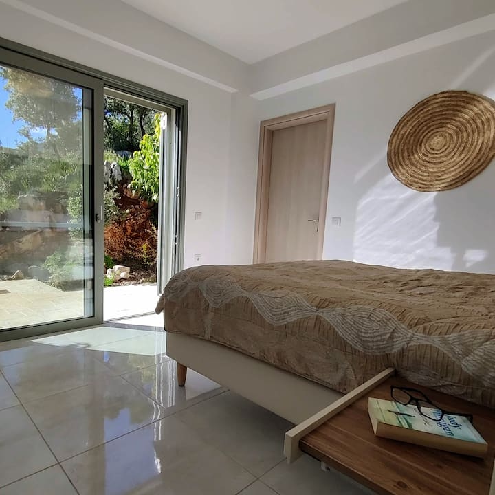 De hoofdslaapkamer. De hoofdslaapkamer van Villa Espmia is een rustig toevluchtsoord met een prachtig uitzicht op de natuur. De stijlvolle, moderne inrichting zorgt voor een ontspannen sfeer voor een goede nachtrust.