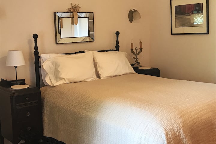 Cama tamaño queen con cubrecamas de plumas. Ropa de cama de primera calidad.