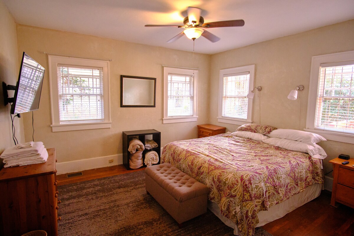 غرفة نوم رئيسية مع تلفزيون روكو 55بوصة وسرير بحجم كبير.