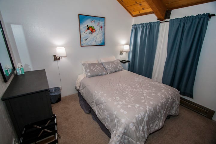 The lower bedroom has a queen memory foam mattress. It also has a 32" smart TV with Chromecast. There's also blackout curtains if you're the type that likes to sleep in.