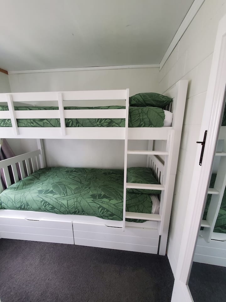 Chambre au rez-de-chaussée avec des lits simples superposés.