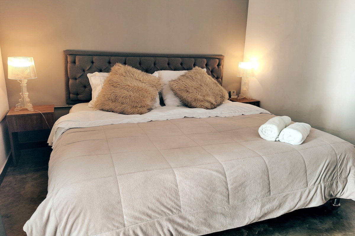 Dormitorio #1 con cama doble XL y acceso al balcón