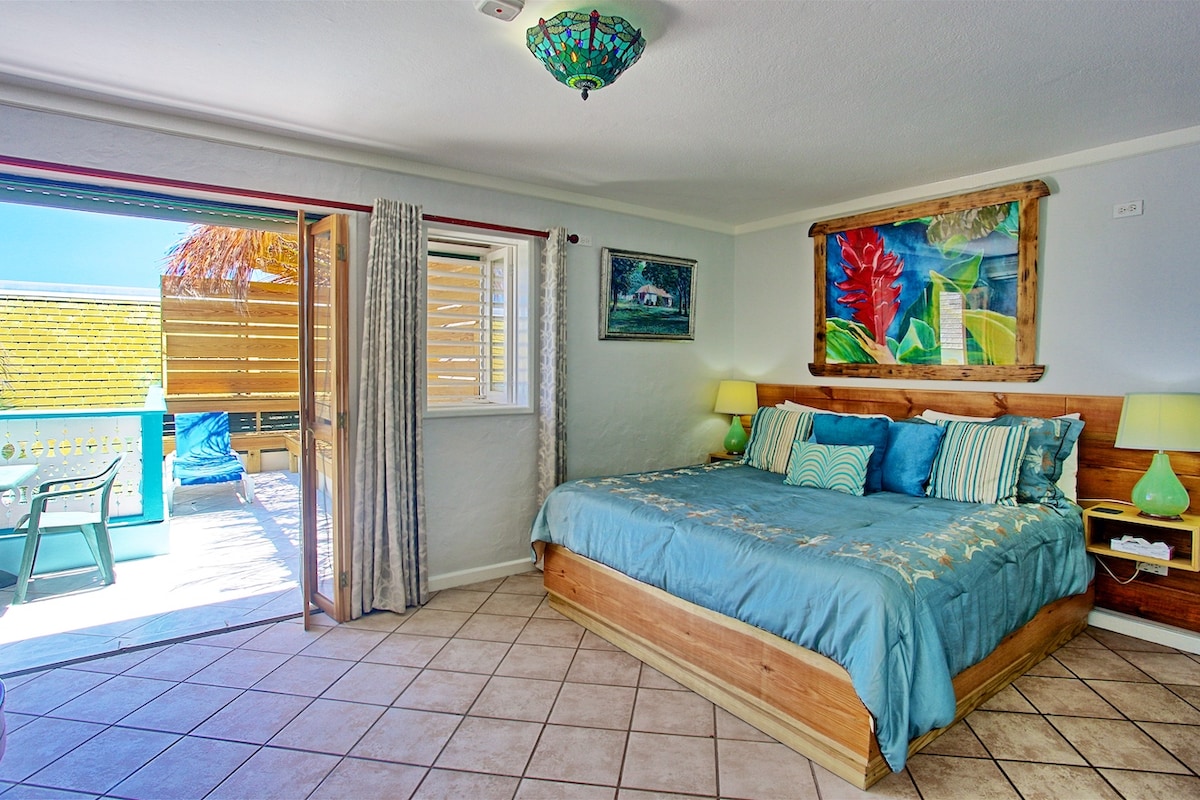 Dormitorio 7. Cama tamaño king, TV, baño privado con ducha, balcón con vistas a la piscina y al mar Caribe, amplia zona de estar.