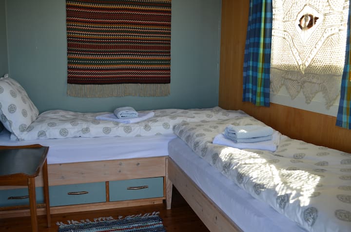 Dormitorio con dos camas individuales y entrada privada desde la terraza.
