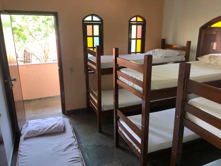 Chambre 4 située au dernier étage avec un balcon privé composé de 3 lits superposés et 1 lit simple et espace avec étagères pour ranger vêtements et effets personnels