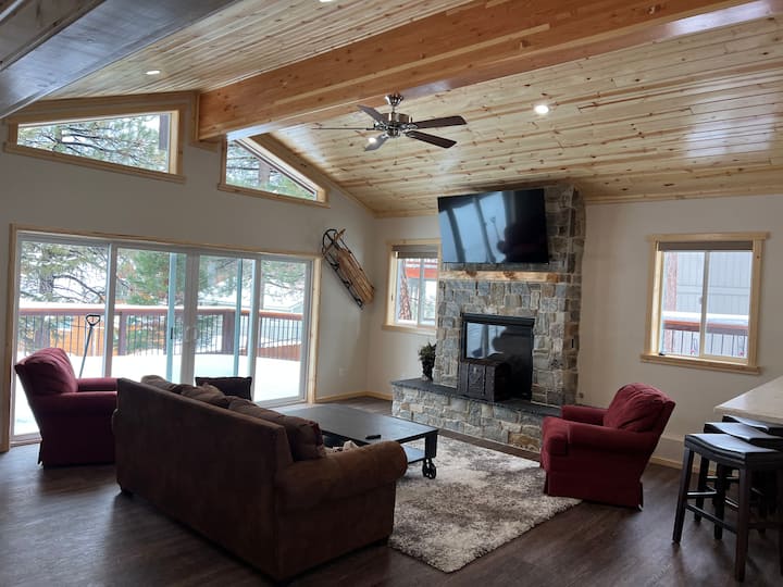 Amplia sala de estar con chimenea, bar y TV.