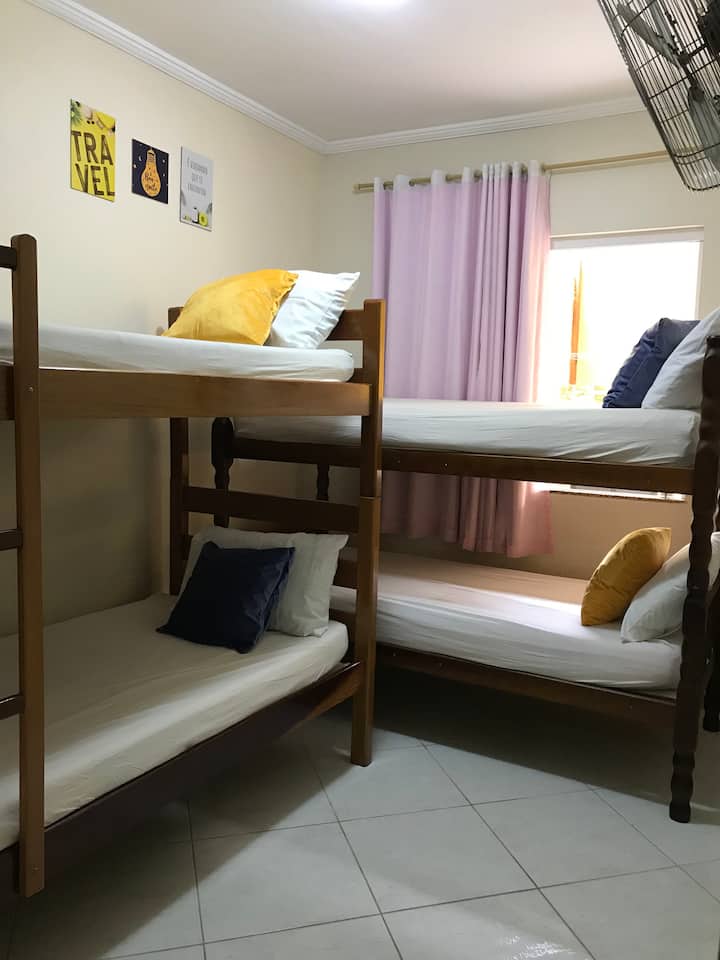 Room with 2 bunk beds, with 4 single beds. As shown. Wall fan, and curtain on the window.