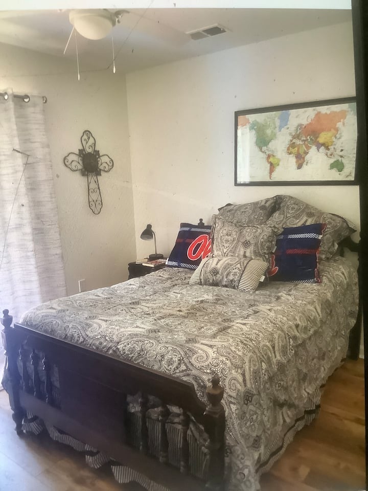 Cama doble con televisión y acceso a la terraza de arriba con vistas al campo de golf.