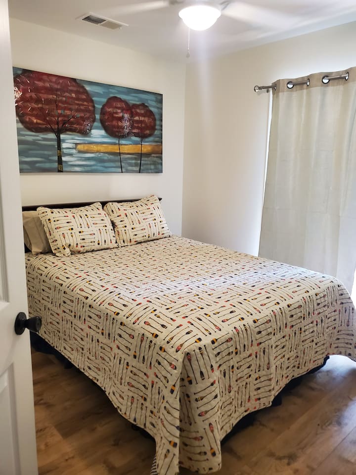 Cama queen en la planta superior con acceso a la terraza cubierta exterior de arriba con muebles de patio y ventilador de techo.