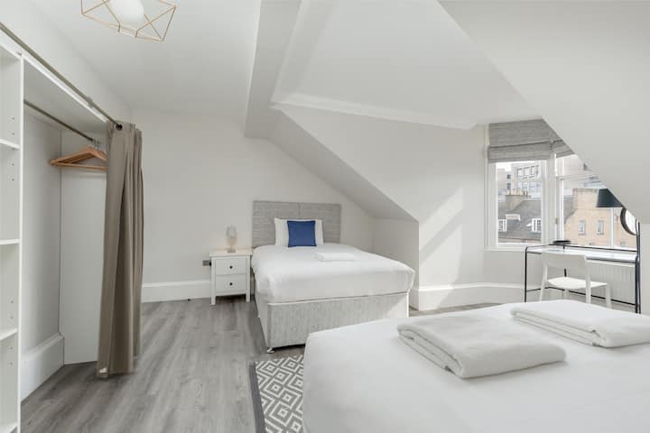 卧室的第二景观，配有2张双人床、套房马桶和水槽