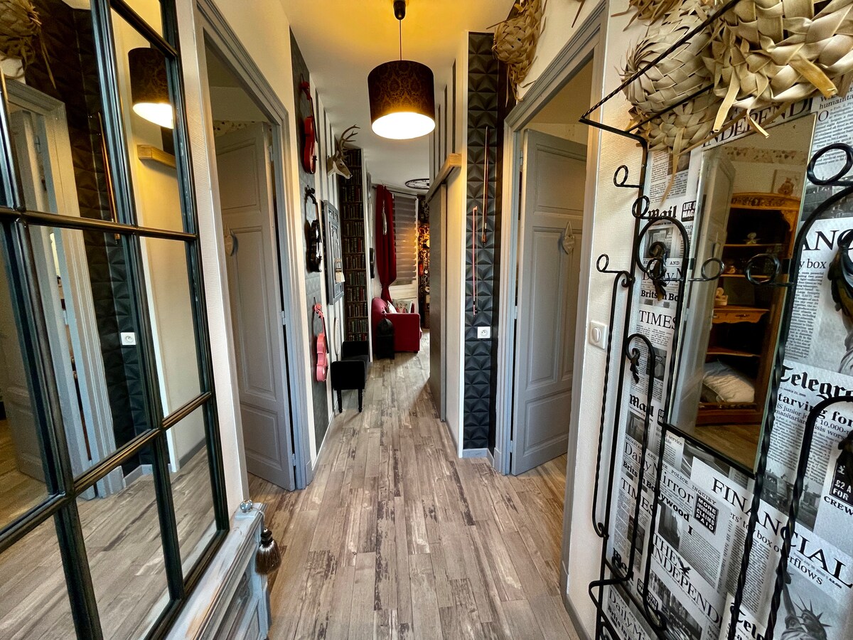 The hallway features stylish wall decor and mirrors, creating a sense of depth. Light fixtures offer illumination, while doors lead to various rooms. Warm, neutral tones enhance the welcoming atmosphere of the entrance space.