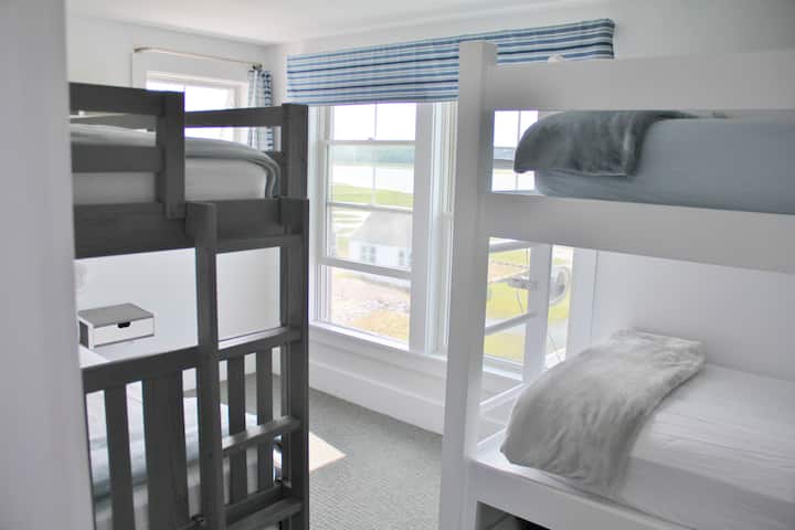 三楼双层床房。空间可供打包玩耍。  灰色双层床下有一张可拉伸的床。  衣柜里有一个梳妆台。