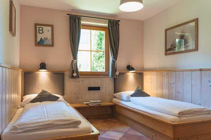 חדר שינה שני עם שתי מיטות יחיד, מלתחה מובנית ונופי גן מרהיבים