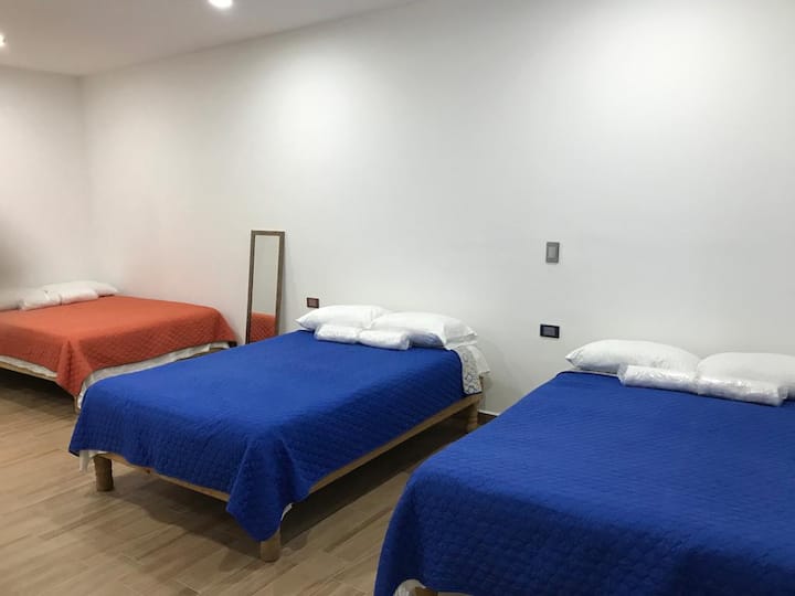 Спална соба со три брачни кревети и клима уред