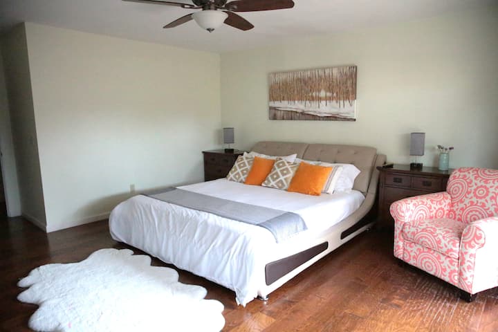 Dormitorio principal con cama tamaño king, TV, baño privado, patio privado y masaje de espalda y cuello.