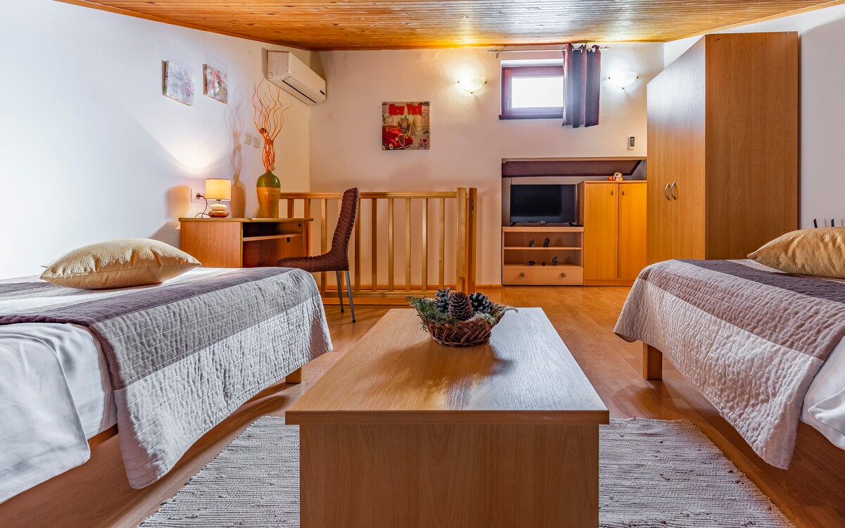 غرفة جميلة مع تلفزيون ومكيف هواء في العلية مع حمام.