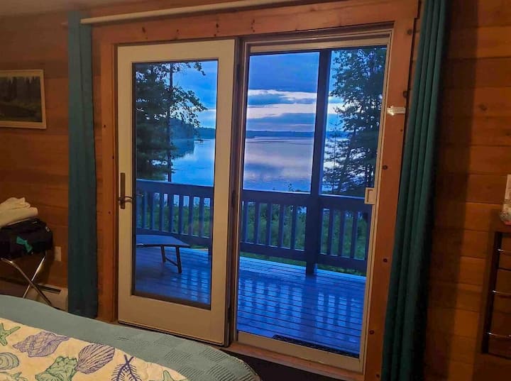 La habitación Riverview está amueblada con cama tamaño queen y tiene acceso al porche con vistas al río Jordan.