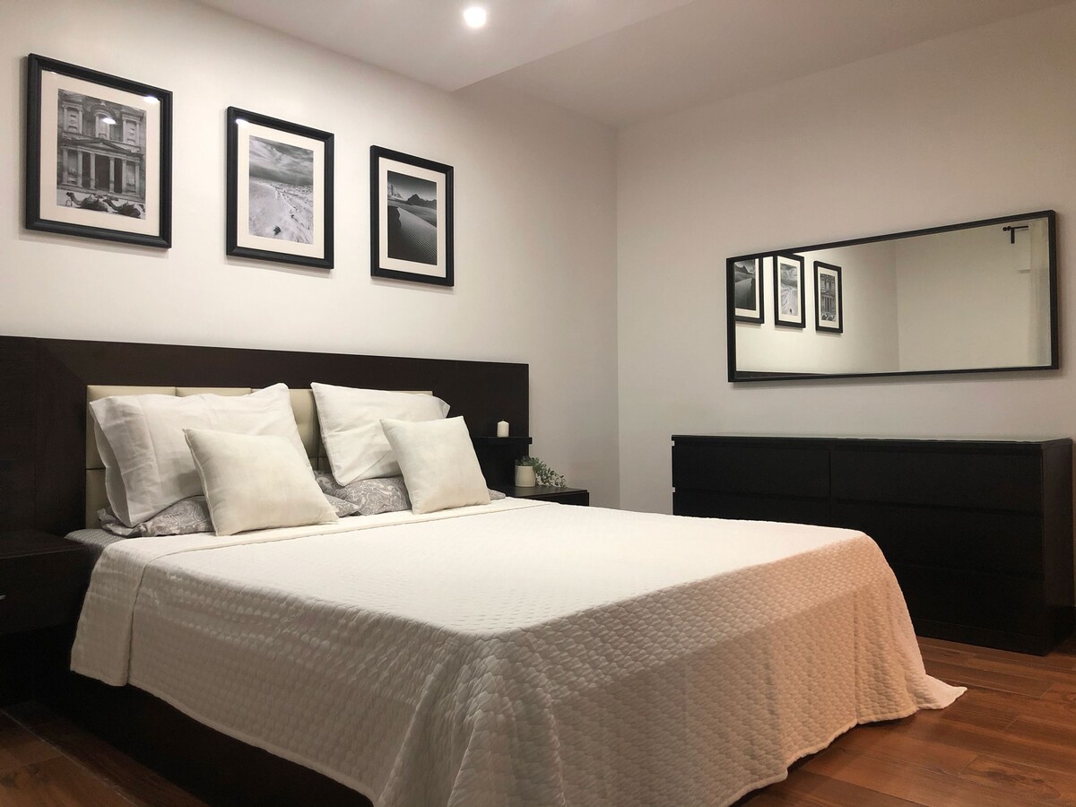 غرفة النوم الرئيسية - غرفة واسعة بسرير بمقاس كينج ومساحة تخزين كبيرة.