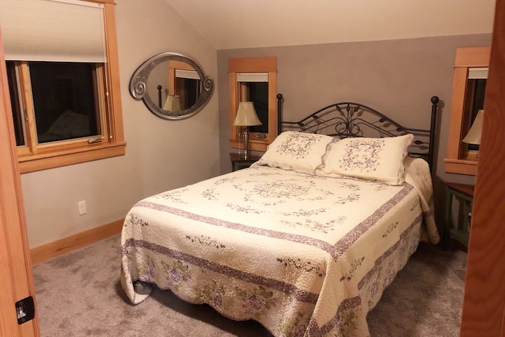 Dormitorio acogedor con sombrillas duette oscurecidas. La cama tamaño queen es firme y cómoda, con un sobrecolchón templado.