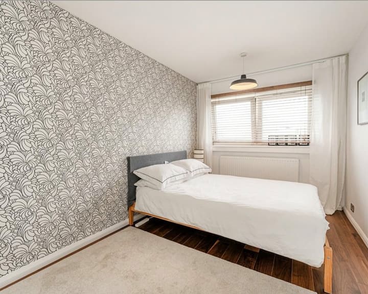 Dormitorio luminoso y tranquilo con una cómoda y un amplio espacio para colgar