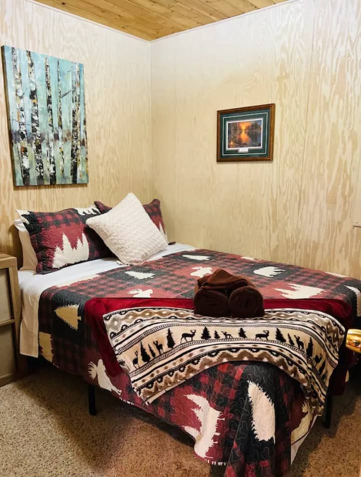 Bedroom with queen bed in small cabin area 